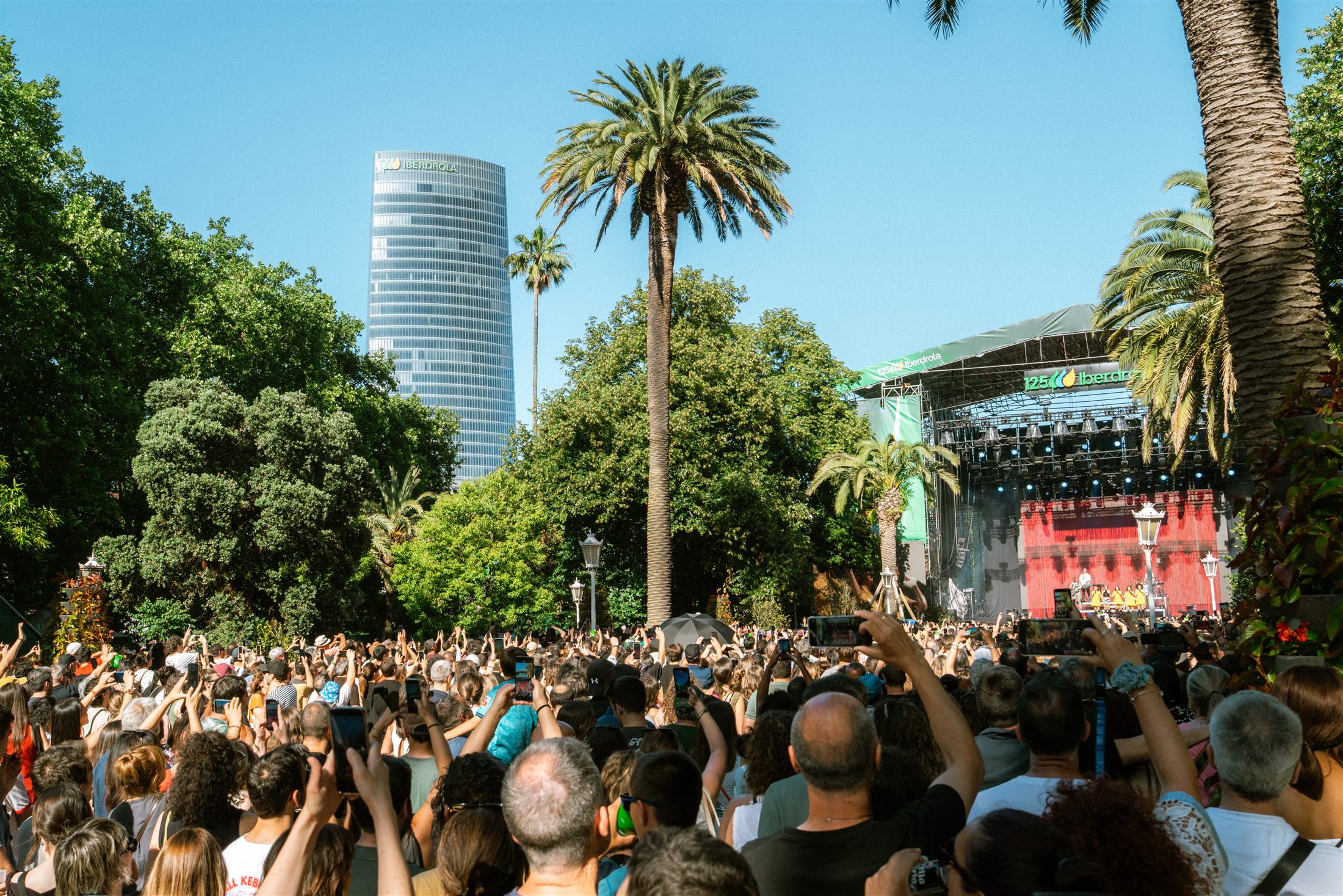 Multitud siguiendo la actuación en el Iberdrola Music Festival de Bilbao, con la Torre Iberdrola al fondo - fotografía de Noland Live