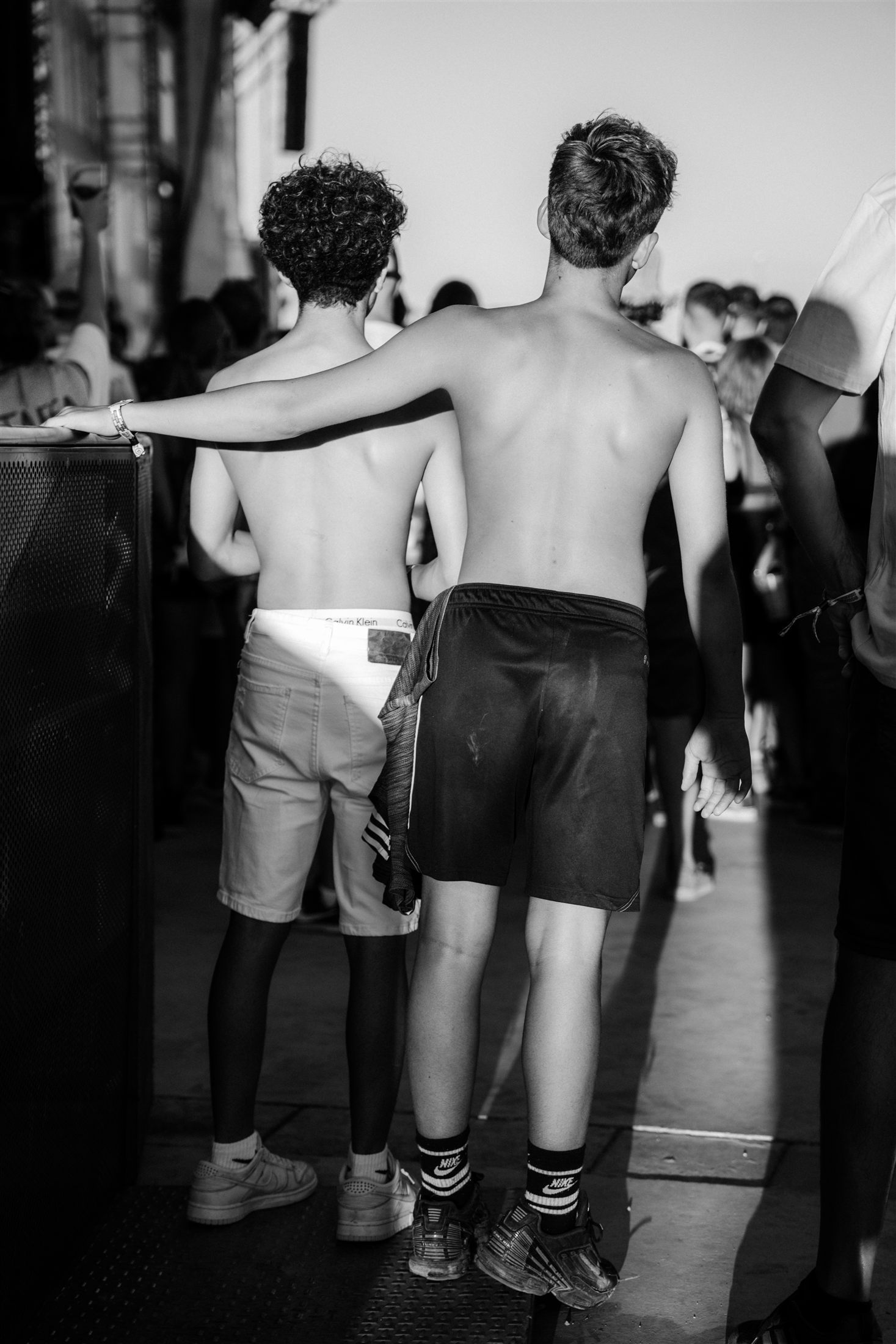 Dos amigos abrazados de espaldas en blanco y negro