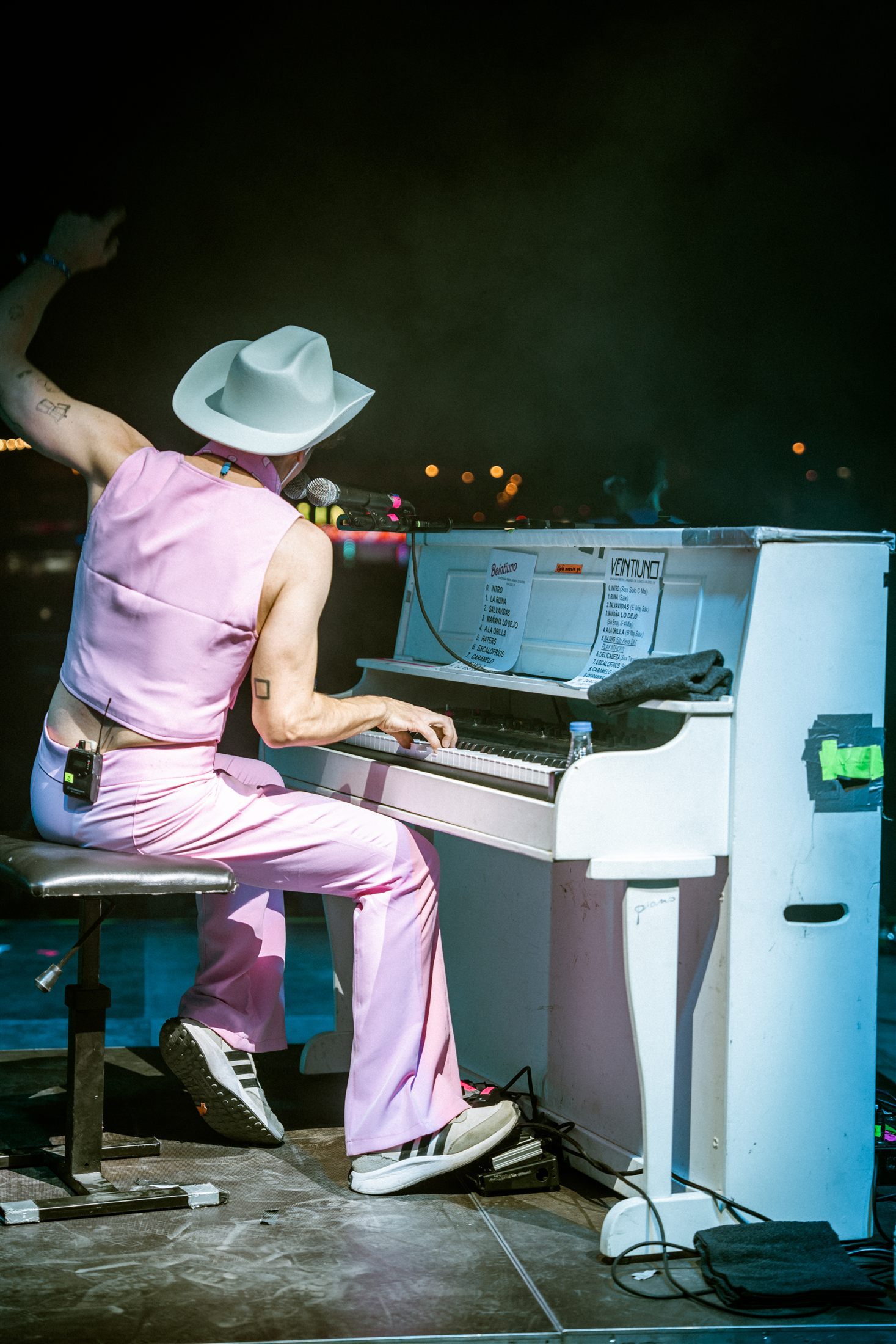Artista al piano con luces azules y vestuario rosa