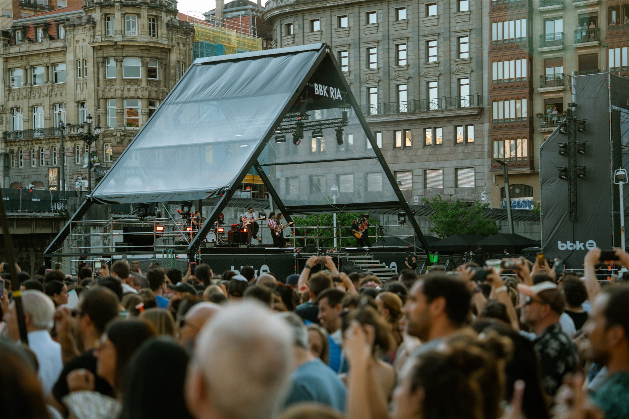 Escenario triangular de BBK Ría junto al skyline de Bilbao