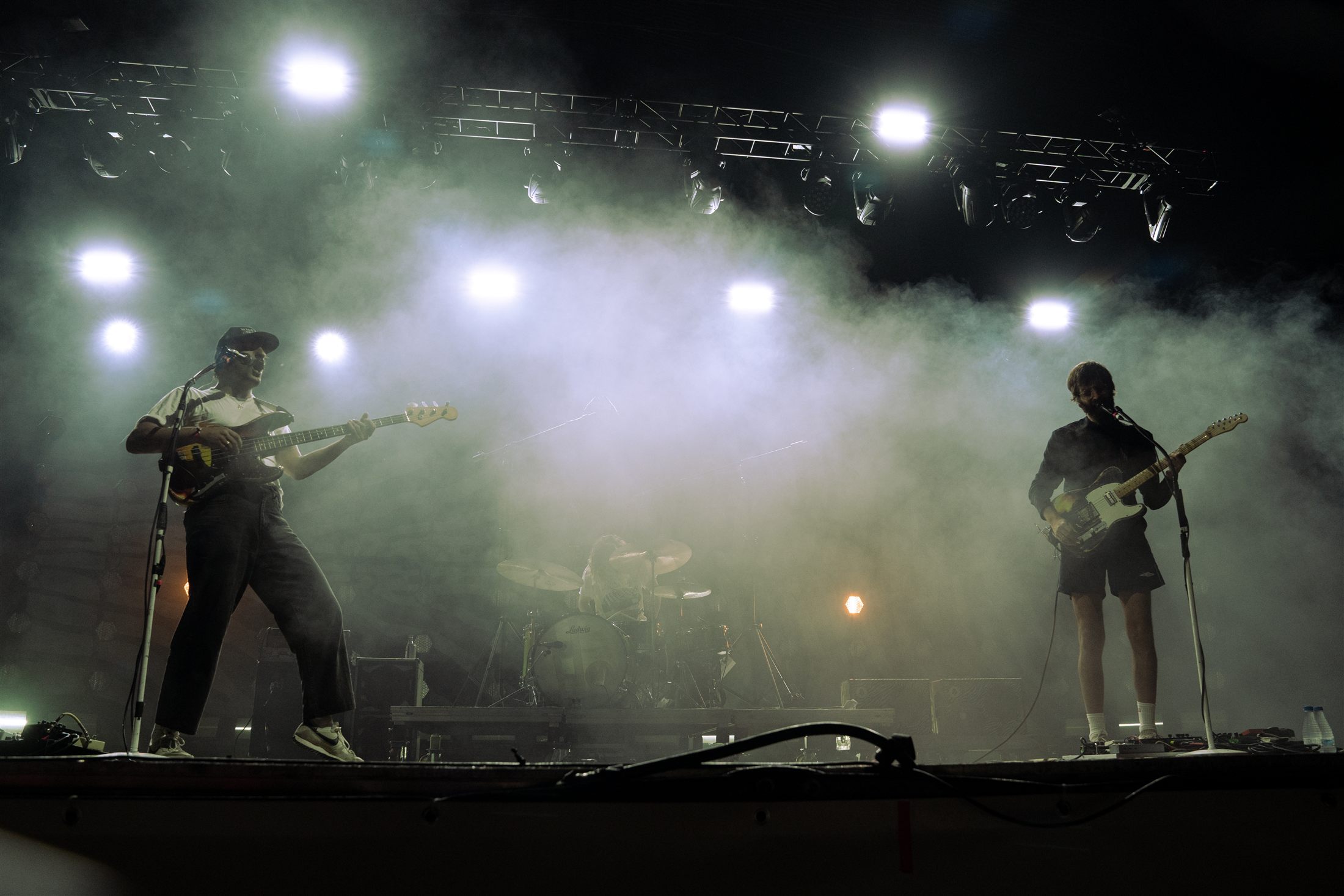 Dos guitarristas silueteados sobre un escenario entre humo