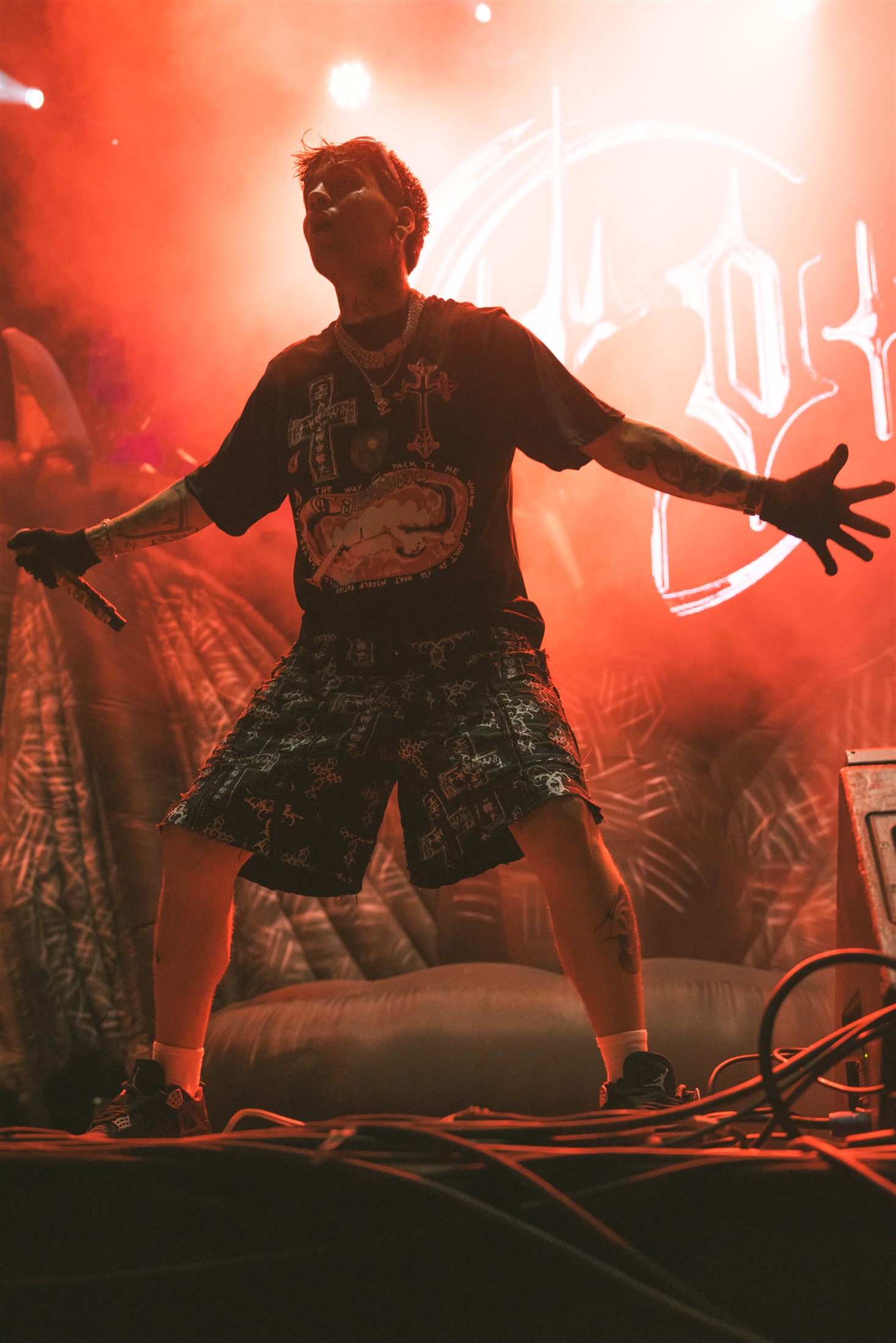 Cantante actuando ante un cartel iluminado sobre un fondo tropical