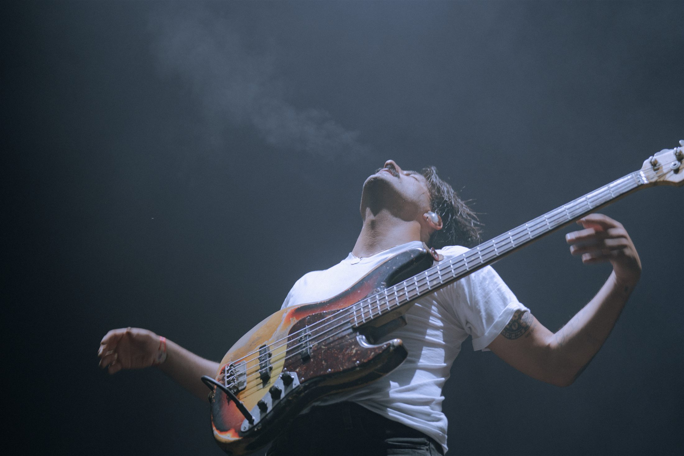Bajista con la cabeza hacia atrás tocando en directo