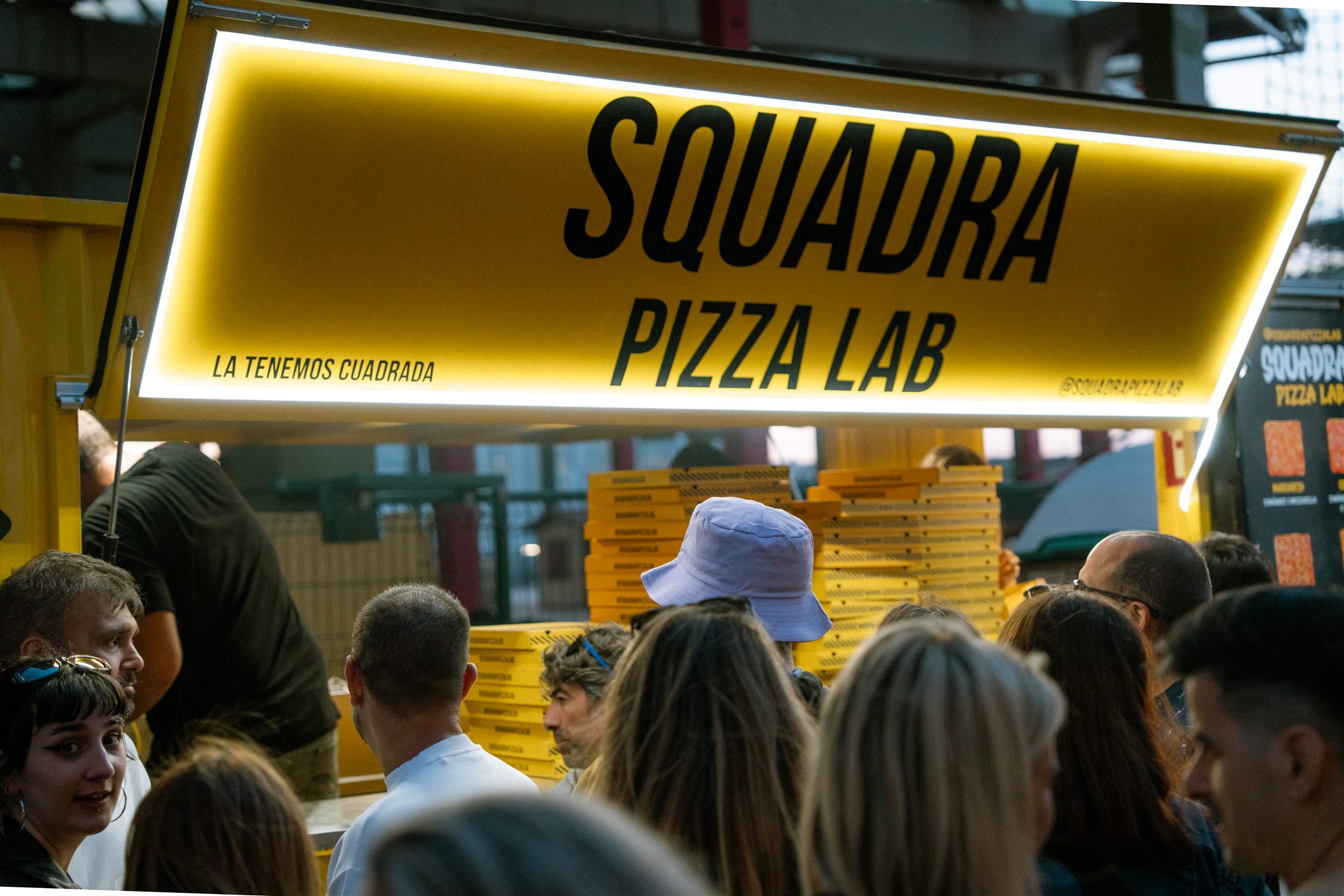 Cartel de un puesto de pizza durante un festival